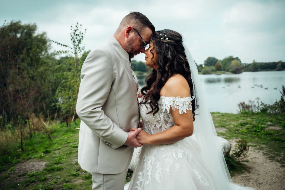 Bruid met sluier in witte jurk bij raam – lichtinval portret trouwfotografie