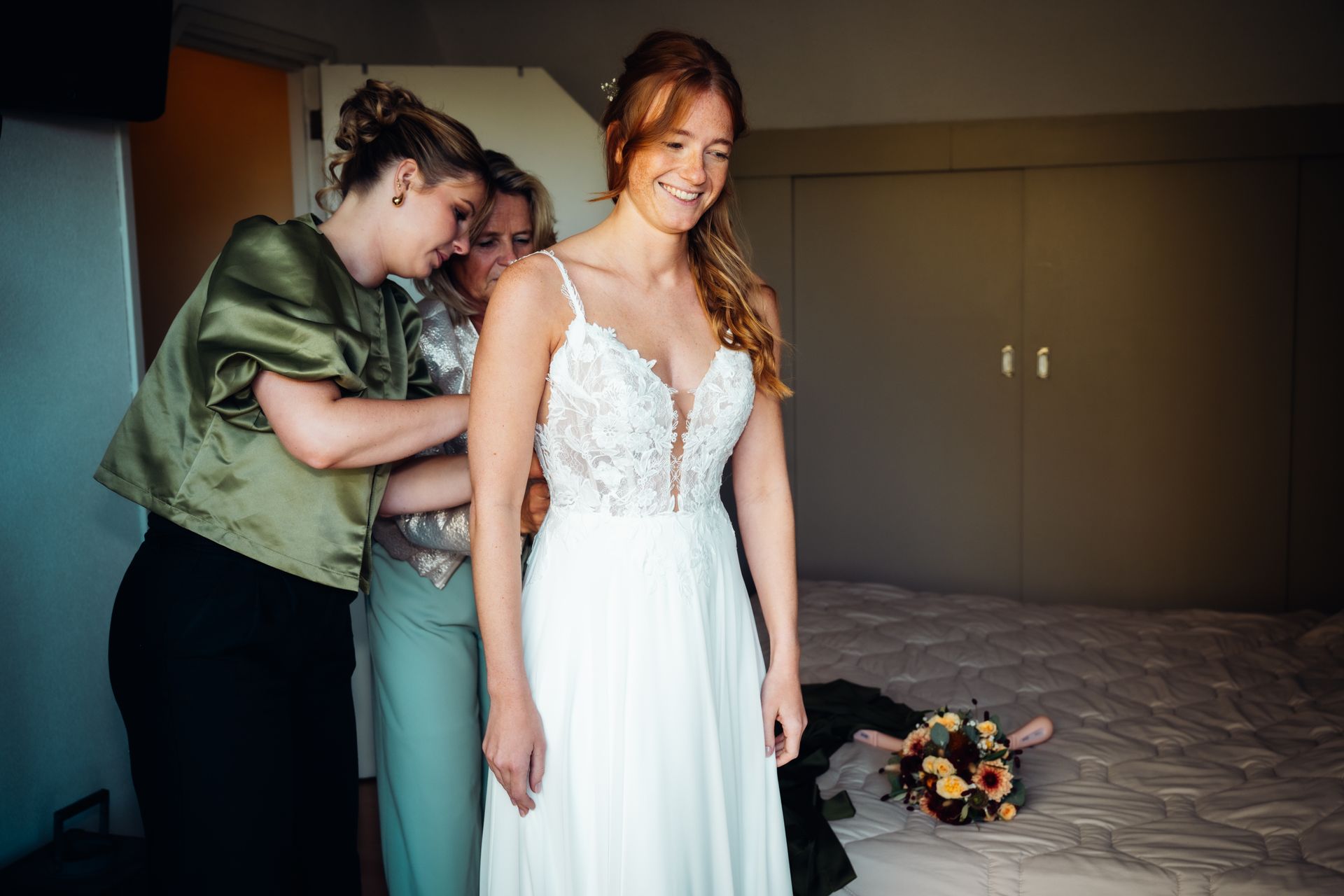 Bruid trekt trouwjurk aan met hulp bruidsmeisjes – getting ready moment