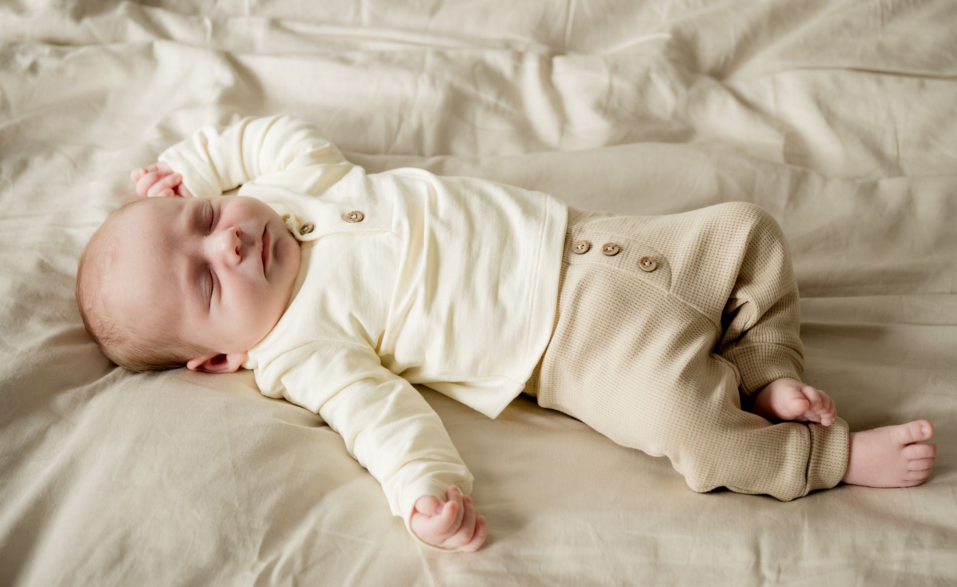 Lifestyle newborn fotoshoot – lachende baby op bed door Charlène Fotografie, newborn fotograaf Boxtel