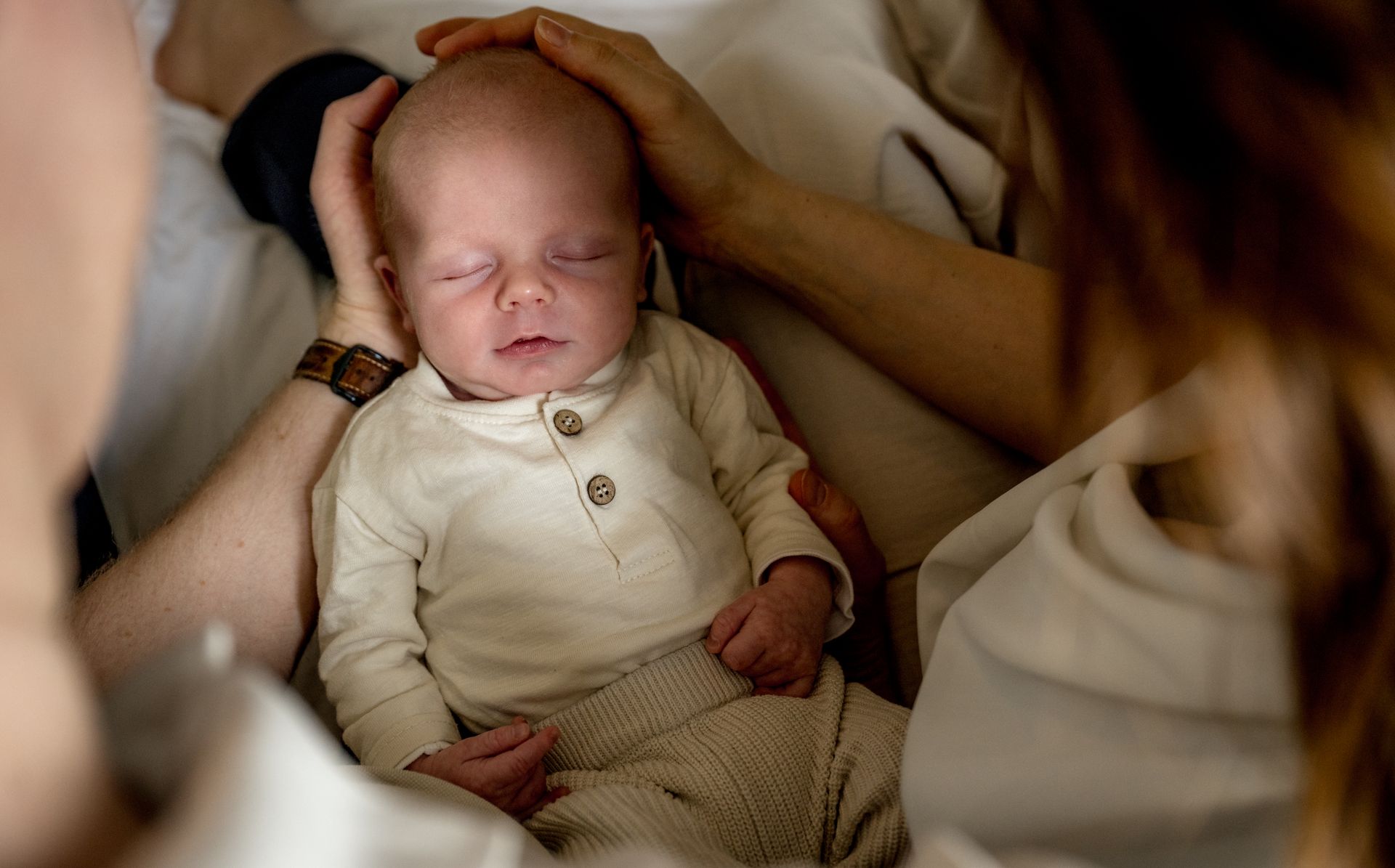 Newborn fotoshoot – moeder met pasgeboren baby bij raam, authentieke lifestyle foto Charlène Boxtel
