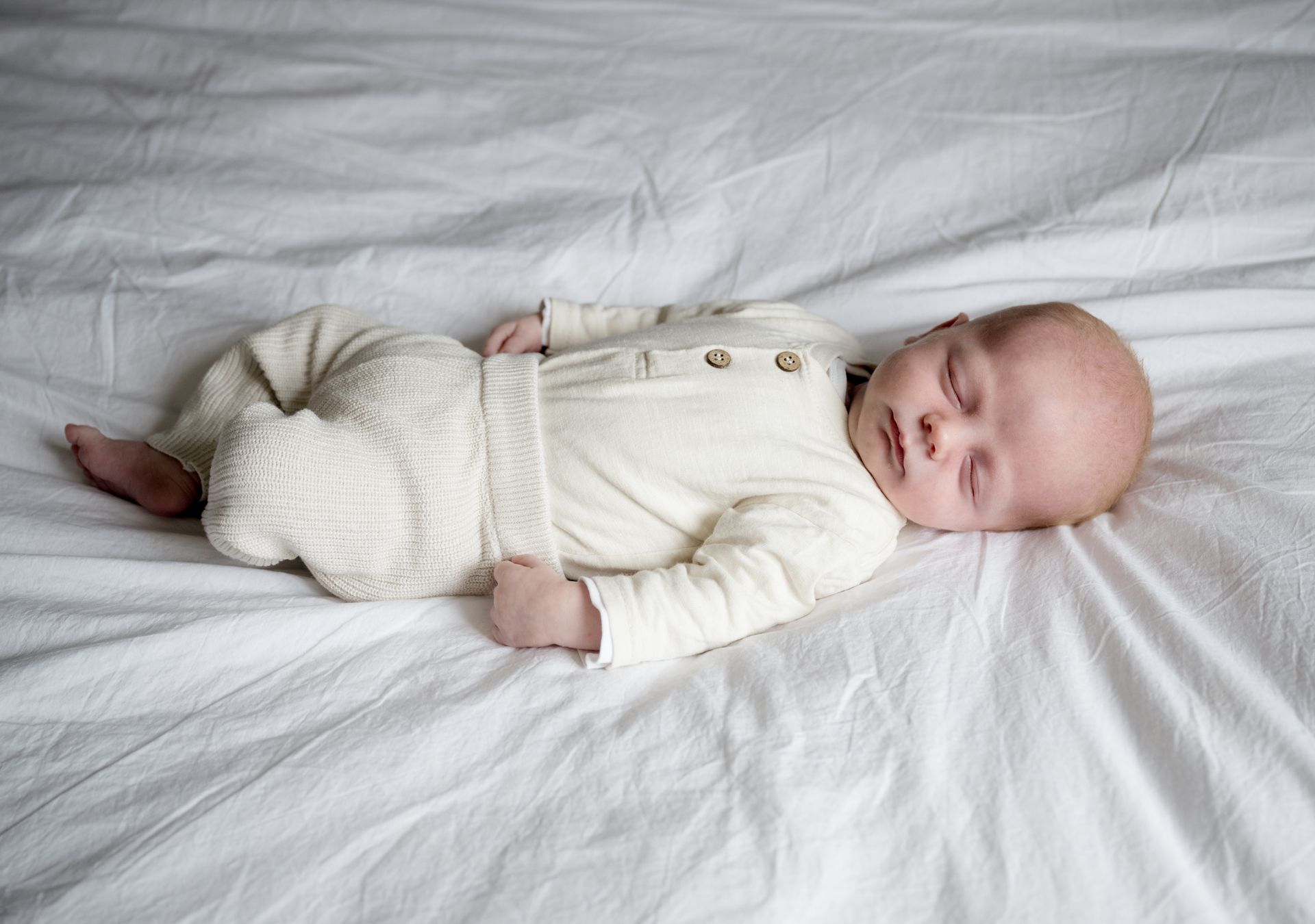 Lifestyle newborn fotoshoot – peuter kijkt naar pasgeboren broertje of zusje thuis in Boxtel