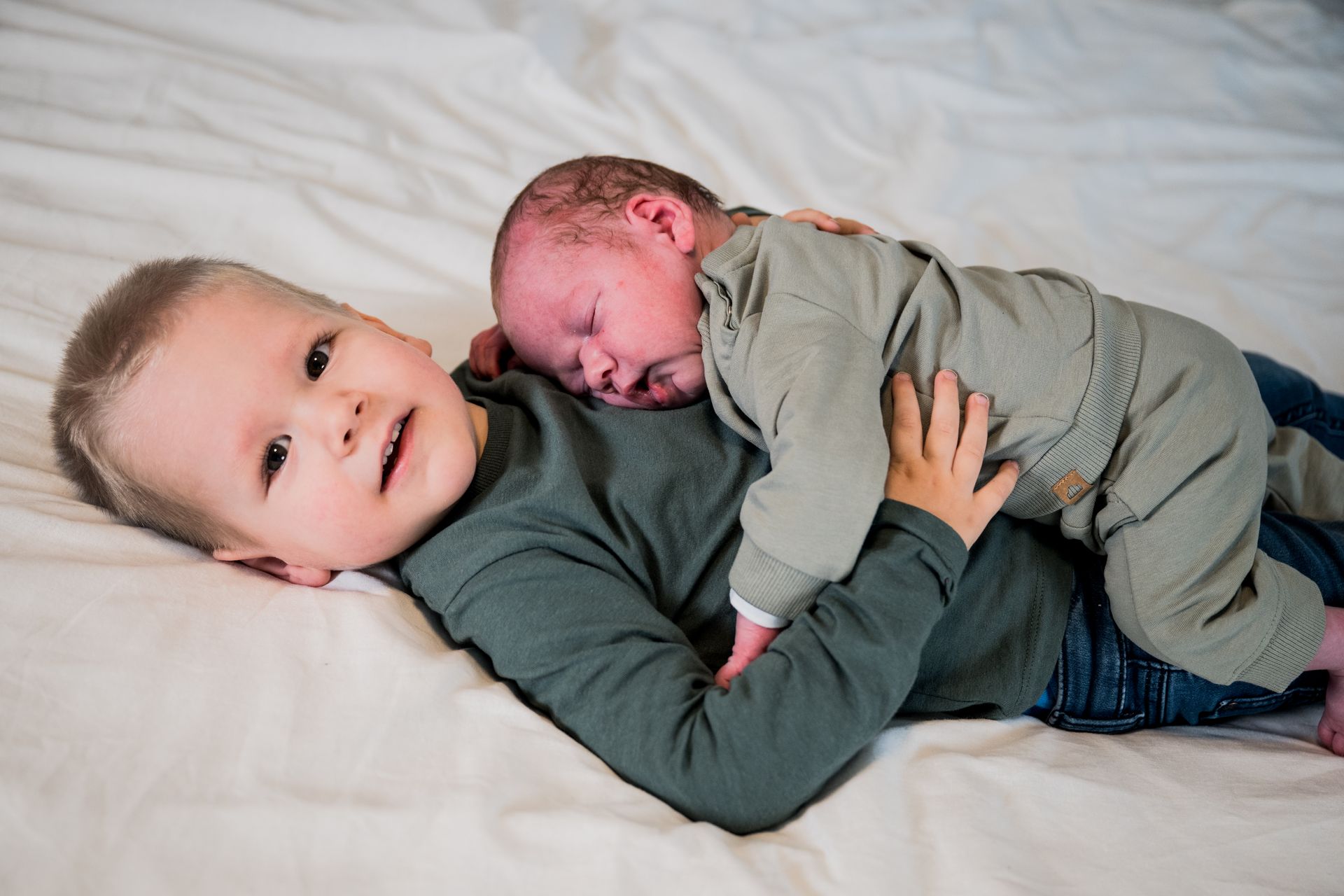 Pasgeboren baby in armen van vader – warme lifestyle newborn foto door Charlène Fotografie