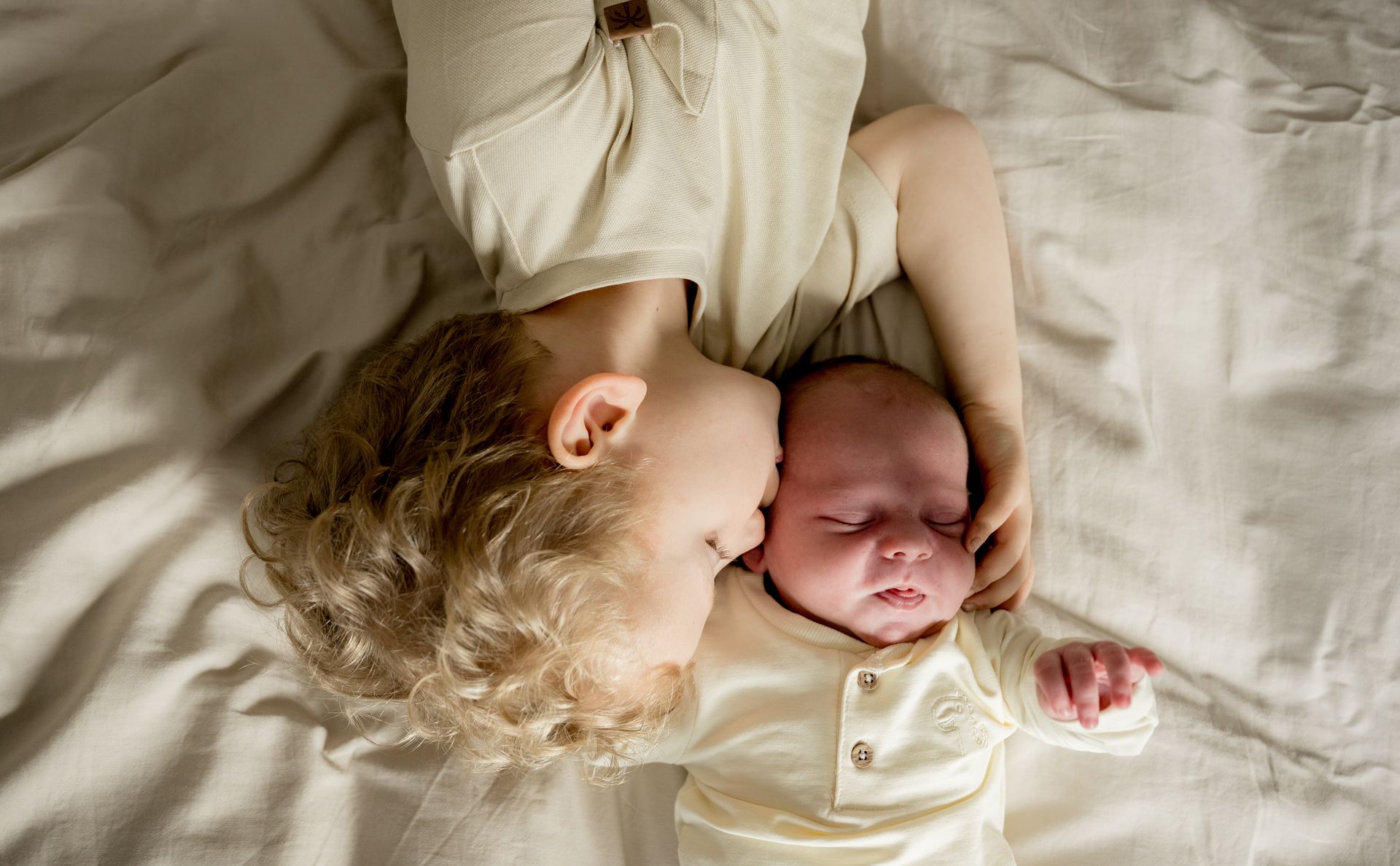 Newborn fotoshoot thuis – vader en moeder bewonderen pasgeboren baby op bed, lifestyle newborn Boxtel