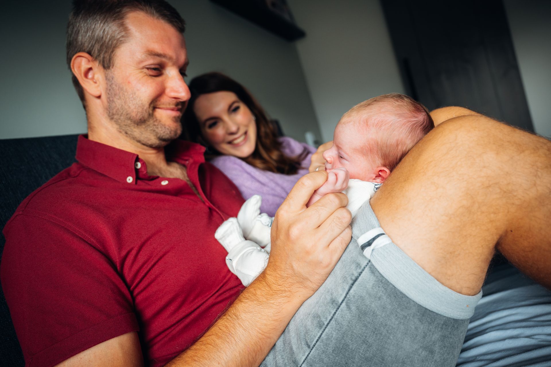 Newborn fotografie – vader kijkt liefdevol naar pasgeboren baby, gezinsfoto door Charlène Fotografie