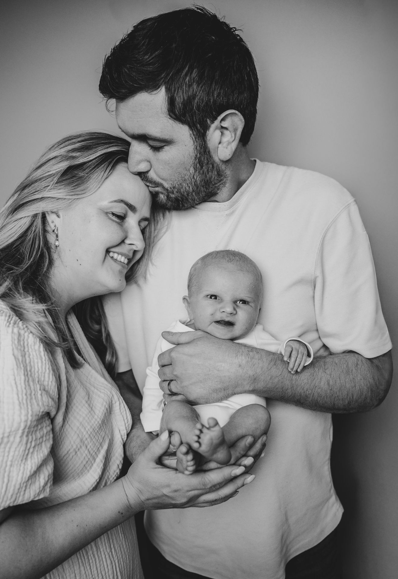 Lifestyle newborn fotografie – vader kijkt lachend naar pasgeboren baby, gezinsmoment Boxtel
