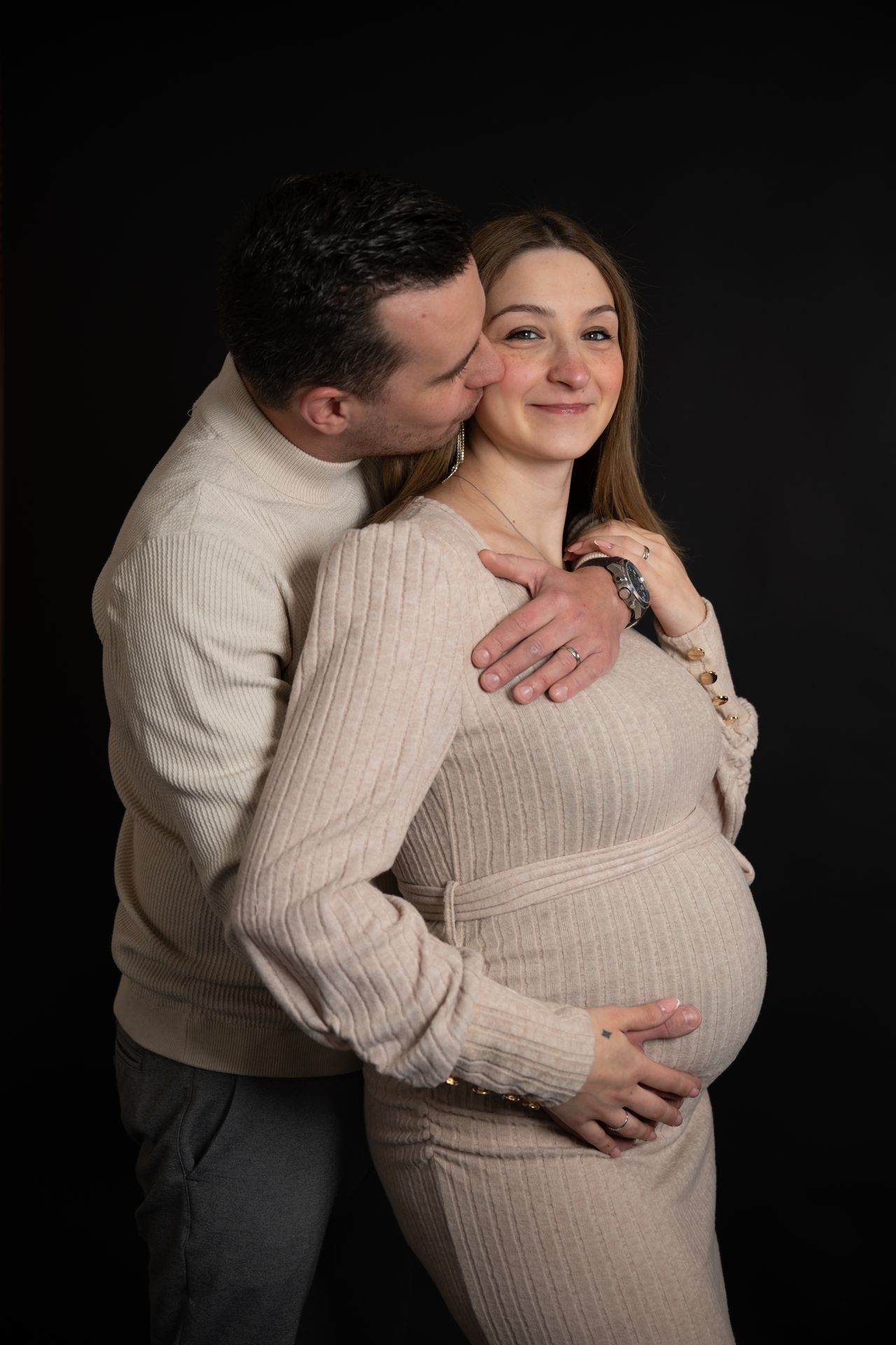 Zwangerschapsfotoshoot koppel – man en vrouw bewonderen zwangere buik, professionele zwangerschapsfotograaf