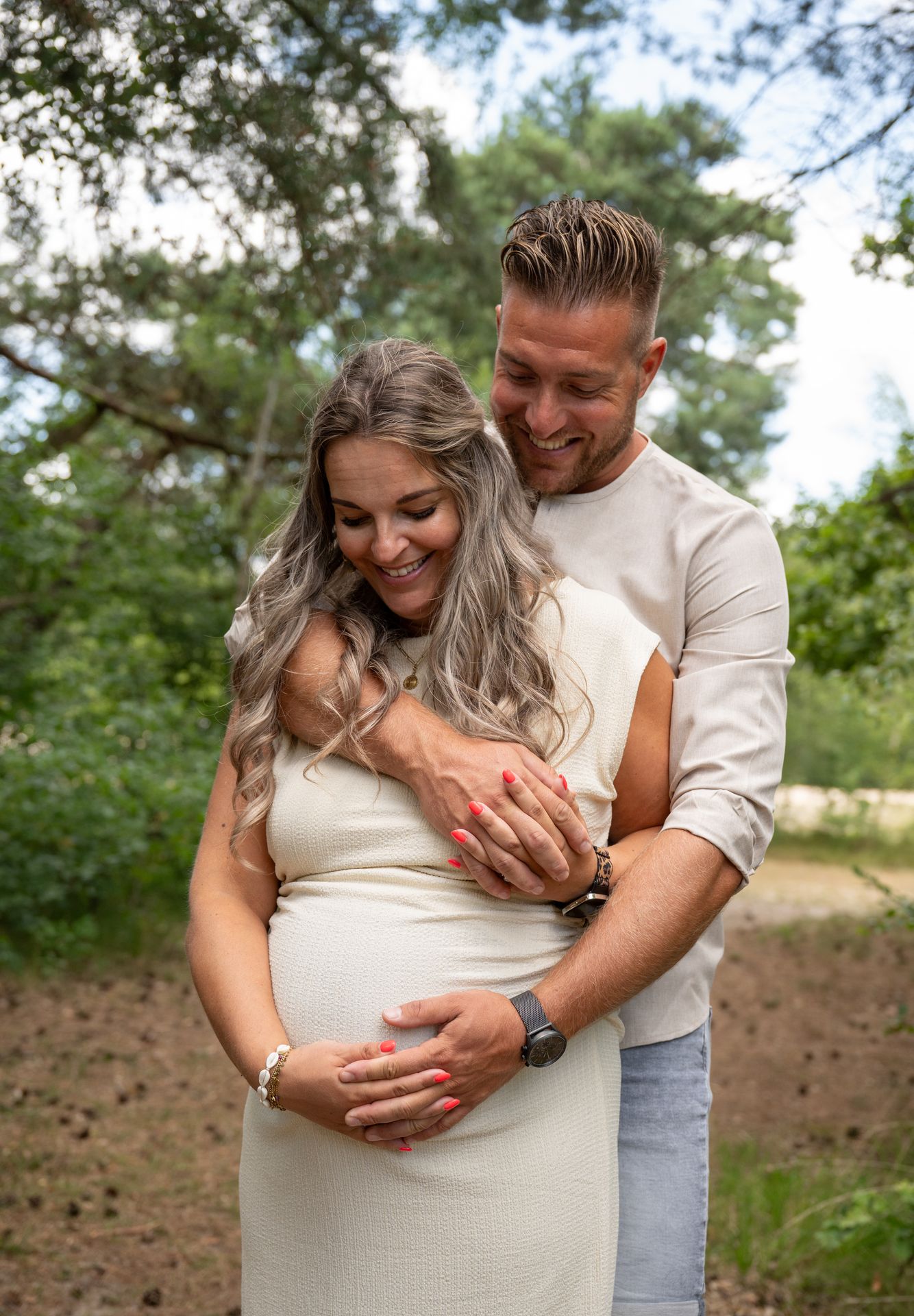Zwangerschapsfotoshoot buiten – lachend koppel in de natuur verwacht baby, buitenshoot zwangerschapsfotograaf